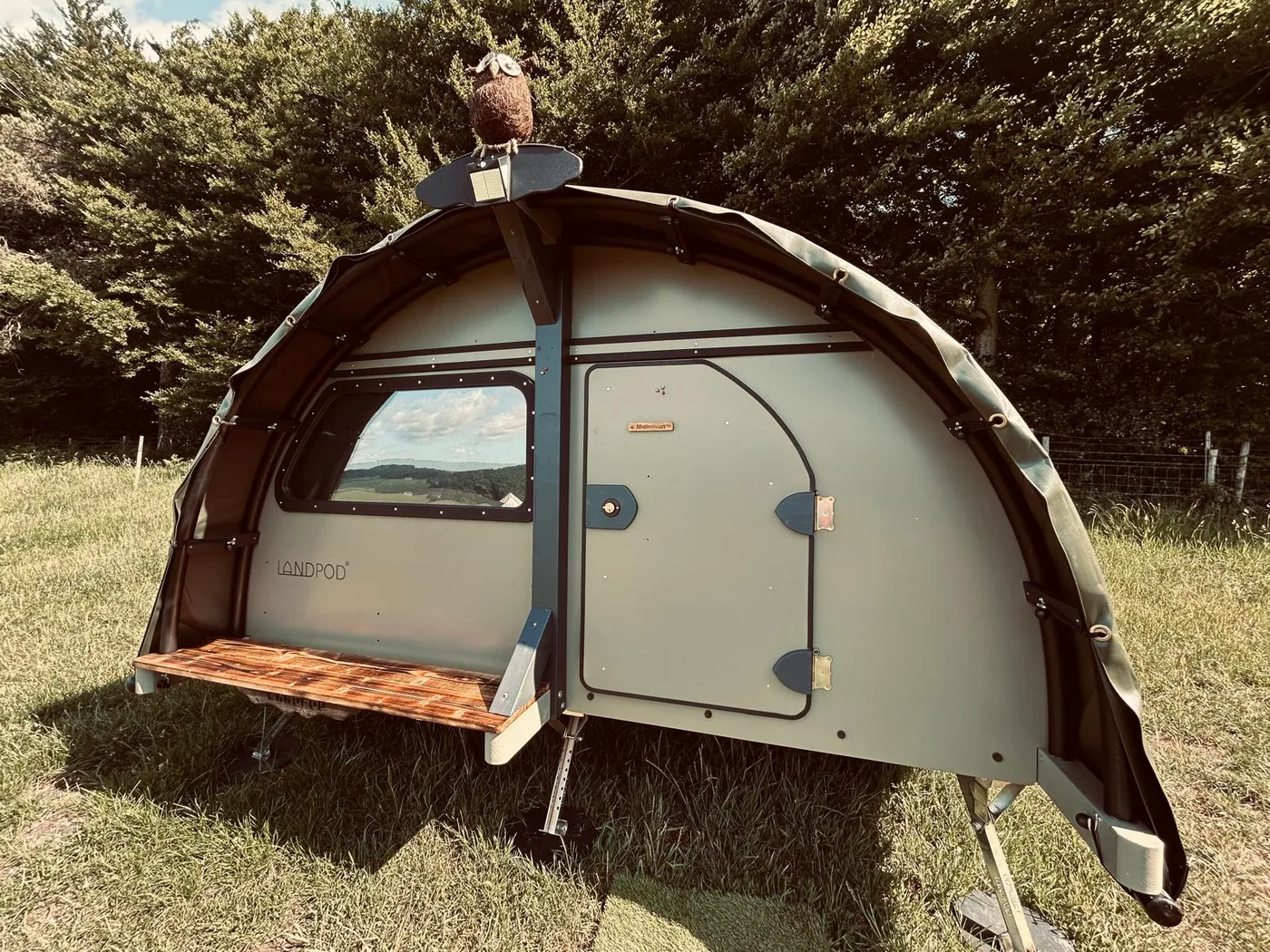 A landpod at Newhouse Farm with its side hatch open onto a timber shelf